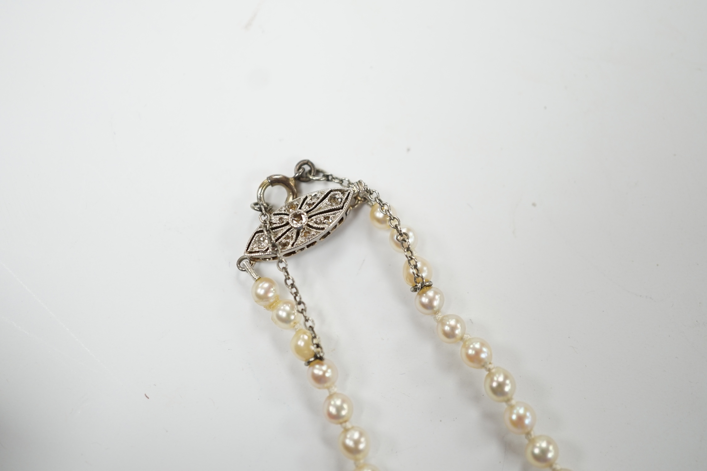 A single strand graduated cultured pearl necklace, with diamond set white metal clasp, 48cm. Good condition.